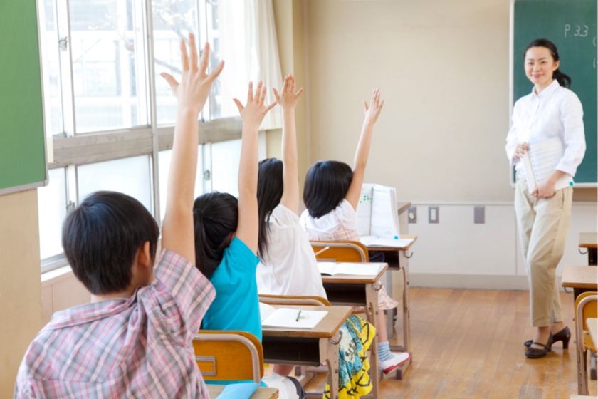 授業で手を挙げる小学6年生